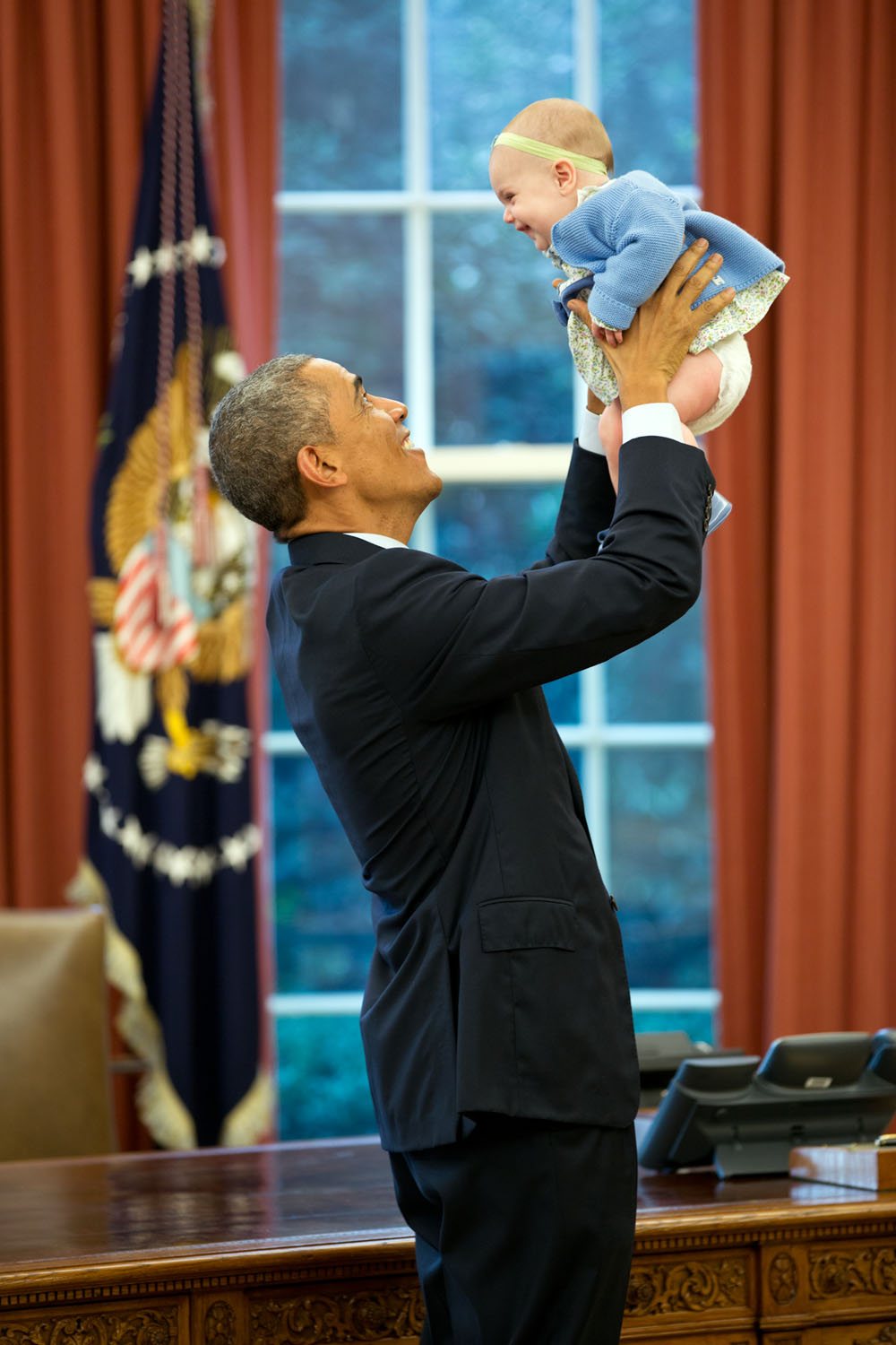 Oct. 14, 2014 "The President lifts the daughter of a departing staff member in the Oval Office." (Official White House Photo by Pete Souza) This official White House photograph is being made available only for publication by news organizations and/or for personal use printing by the subject(s) of the photograph. The photograph may not be manipulated in any way and may not be used in commercial or political materials, advertisements, emails, products, promotions that in any way suggests approval or endorsement of the President, the First Family, or the White House.