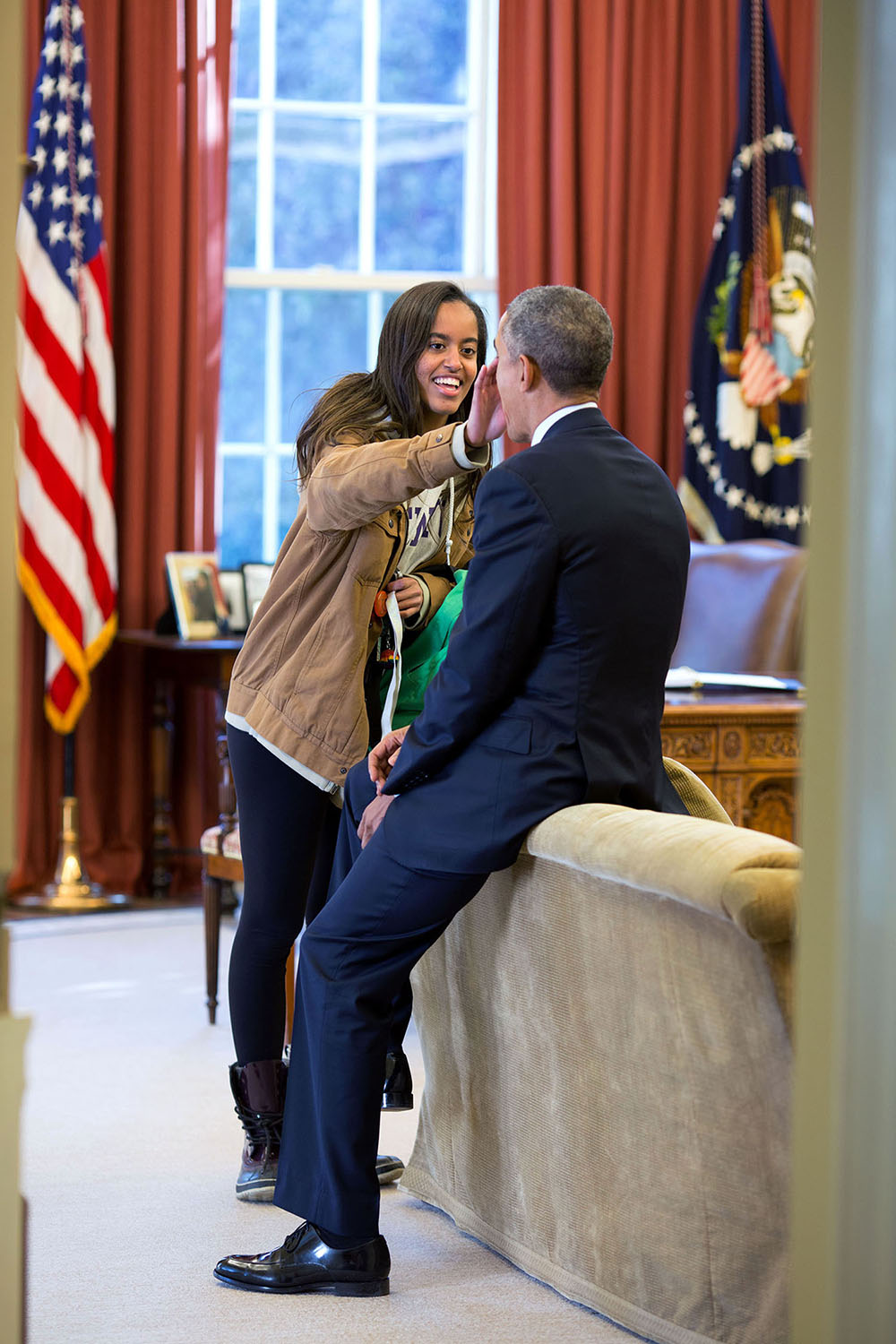 Feb. 23, 2015 "The President's daughter Malia stopped by the Oval Office one afternoon to see her dad and, while they were talking, she wiped something from his face." (Official White House Photo by Pete Souza) This official White House photograph is being made available only for publication by news organizations and/or for personal use printing by the subject(s) of the photograph. The photograph may not be manipulated in any way and may not be used in commercial or political materials, advertisements, emails, products, promotions that in any way suggests approval or endorsement of the President, the First Family, or the White House.