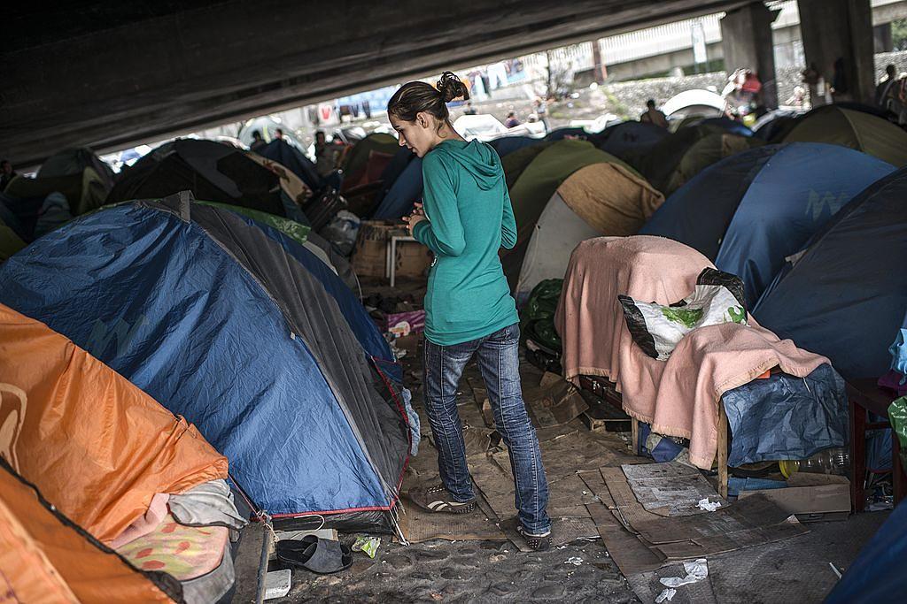 LYON, FRANCE - OCTOBER 23: A woman walks near her tent in an illegal campsite of Albanian asylum seekers, situated under the A6 motorway's Kitchener bridge next to the entrance of the Fourviere tunnel on October 23, 2013 in Lyon, France. A court today ordered the immediate expulsion of the camp of 300 people, including 98 children, who have been camping beneath the highway bridge since July. The interior ministry also said today that it would seek an overhaul of the asylum system. (Photo by Alexander Roth-Grisard/Getty Images)