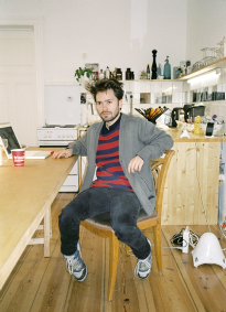 Alexander - 29 - selbstständig: Küche. Er trägt T-Shirt von Fred Perry und Ralf Simons For Fred Perry, Sweater von Wood Wood und Cardigan von Wrangler.