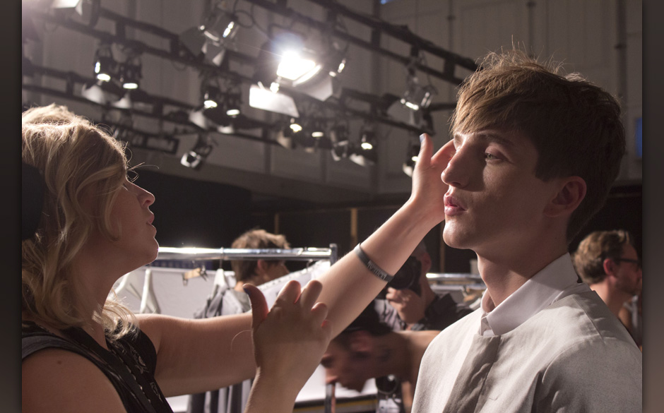 Die Visagistin vollendet ihr Werk.