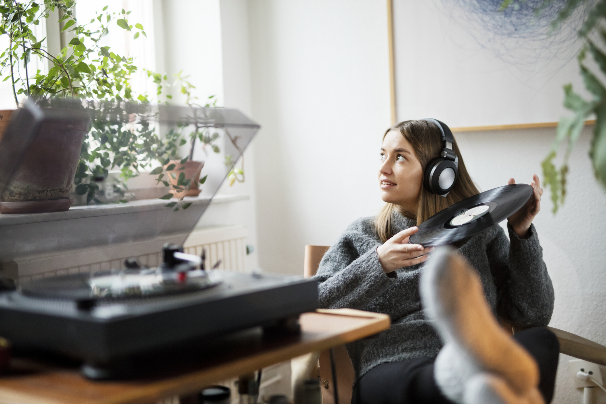 Frau hört Vinylplatte mit Kopfhöhrern