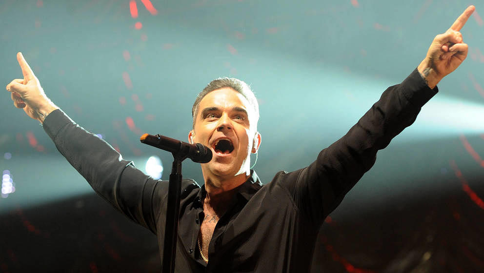 MANCHESTER, ENGLAND - DECEMBER 09:  Robbie Williams performs on stage at Key 103 Christmas Live at Manchester Arena on Decemb