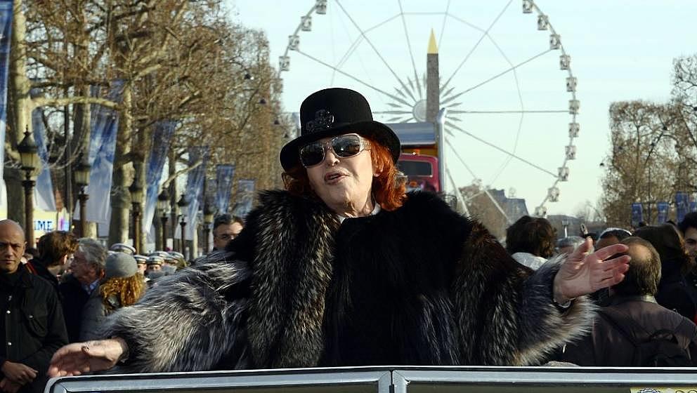 French singer Regine waves to the crowds during a parade, on January 1, 2015, along the Champs-Elysees in Paris to celebrate 