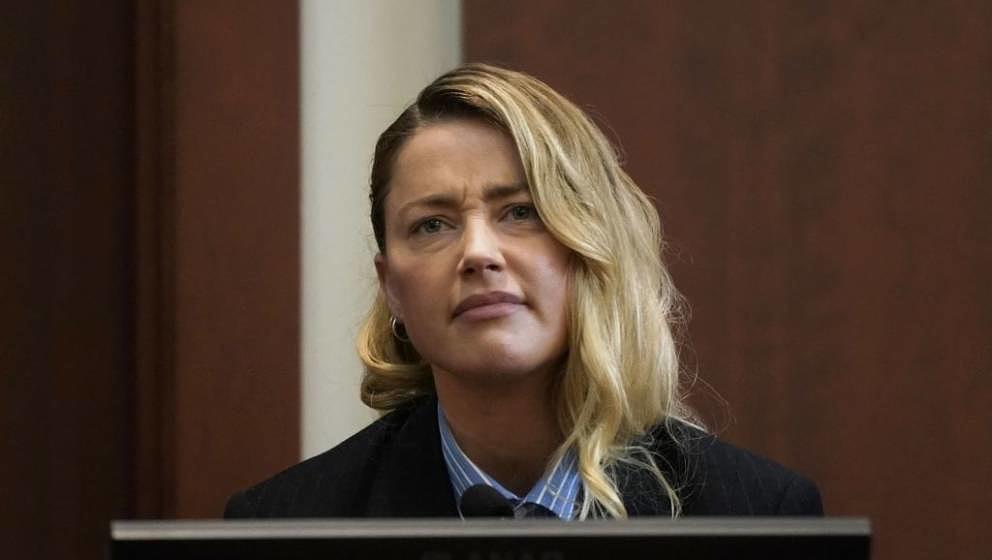 Actor Amber Heard reacts as she testifies at Fairfax County Circuit Court during a defamation case against her by ex-husband,