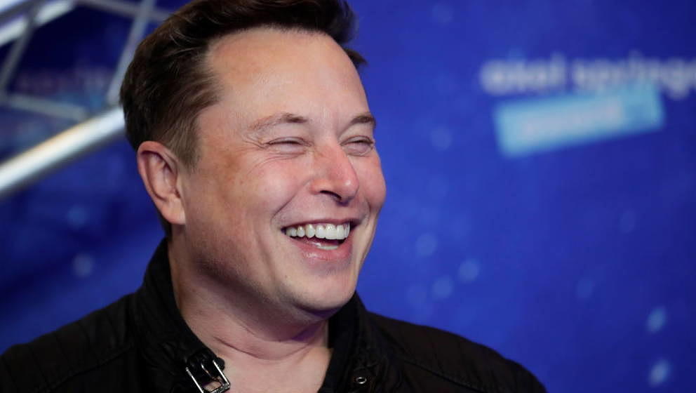 SpaceX owner and Tesla CEO Elon Musk laughs as he arrives on the red carpet for the Axel Springer Awards ceremony, in Berlin,